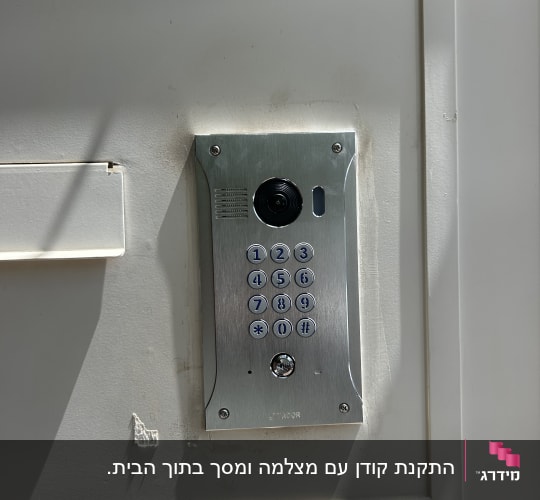 מערכת אינטרקום עם לוח מקשים על קיר לבן